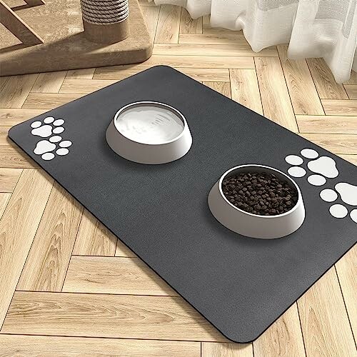 Deux bols pour animaux sur un tapis avec des motifs de pattes.